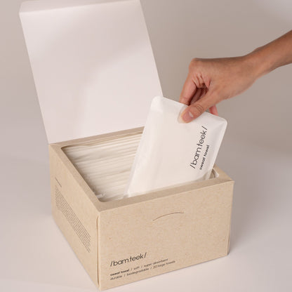 Hands holding a white, textured single-use towel from the Sweat Bundle for active skincare.